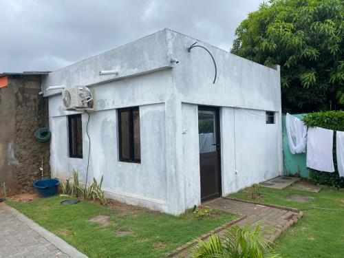 a small white house with a door in a yard at Aeropark Residencial (B&B) in Maputo