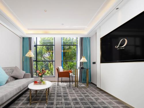 a living room with a couch and a flat screen tv at Pazhou XANA Deluxe International Hotel Pazhou Convention and Exhibition Center Nanzhou Metro Station Branch - Free Shuttle Bus to Canton Fair Complex During Canton Fair Period in Guangzhou