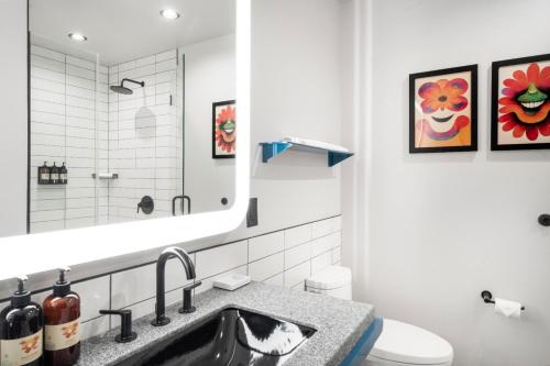 a bathroom with a sink and a toilet and a mirror at Waymore's Guest House & Casual Club in Nashville