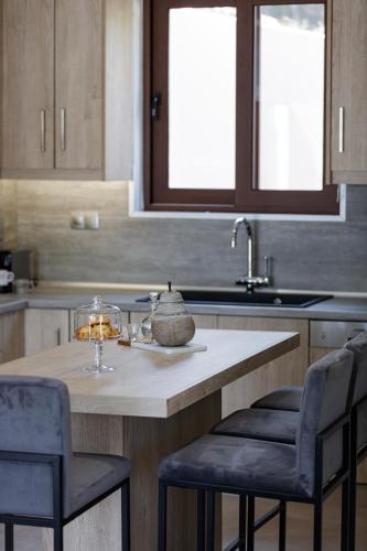 a kitchen with a table with two chairs and a sink at Villa Fotinou Heated Pool & Free Bikes awaits in Fotinós