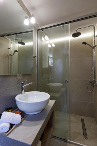 a bathroom with a sink and a glass shower at Villa Fotinou Heated Pool & Free Bikes awaits in Fotinós