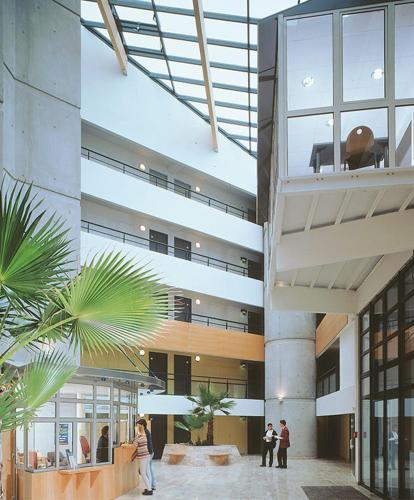 un grand bâtiment avec des personnes marchant dans le hall dans l'établissement Appartement T2 Port Marianne, à Montpellier