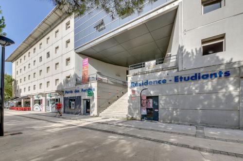 un bâtiment avec une enseigne sur le côté dans l'établissement Appartement T2 Port Marianne, à Montpellier