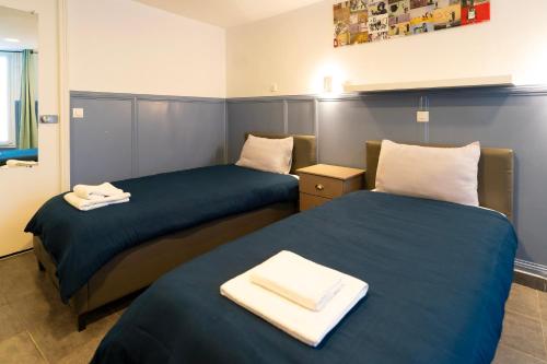 deux lits dans une chambre d'hôtel avec des serviettes dessus dans l'établissement Hotel Geoffroy Marie Opéra, à Paris