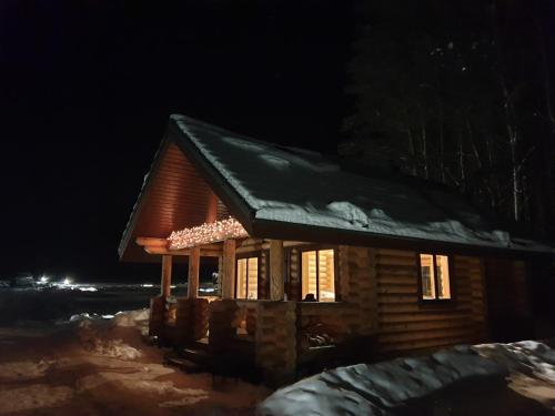 a small cabin with snow on the roof at night at Pušų Šlamesy in Vilnius