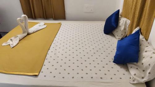 a bed with blue and white pillows on it at SAI HOMESTAY White town in Puducherry