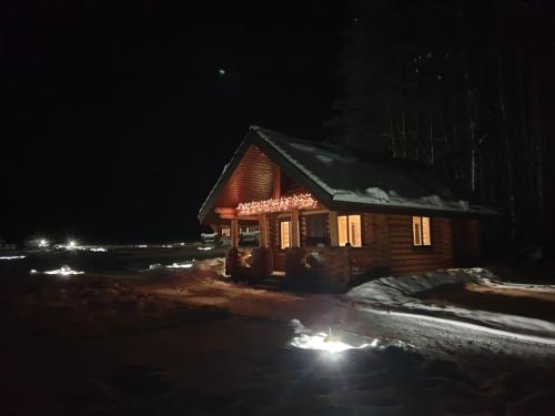 a cabin lit up in the snow at night at Pušų Šlamesy in Vilnius