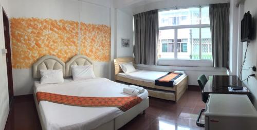 a hotel room with two beds and a window at Room For You in Bangkok