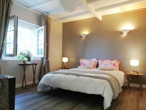 une chambre avec un grand lit avec des oreillers roses dans l'établissement Belle demeure au coeur des Ménafauries, à Charmes-sur-Rhône