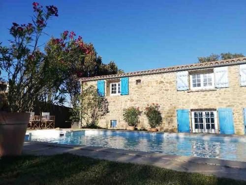 une vue extérieure d'une maison avec piscine dans l'établissement Belle demeure au coeur des Ménafauries, à Charmes-sur-Rhône