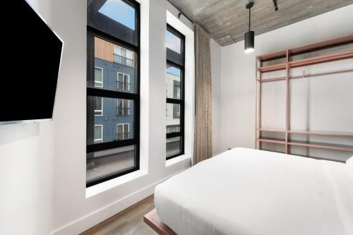 a bedroom with a bed and two windows at Waymore's Guest House & Casual Club in Nashville