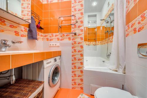 y baño con aseo y lavadora. en Park Lane Inn Apartament Lebedeva, en San Petersburgo