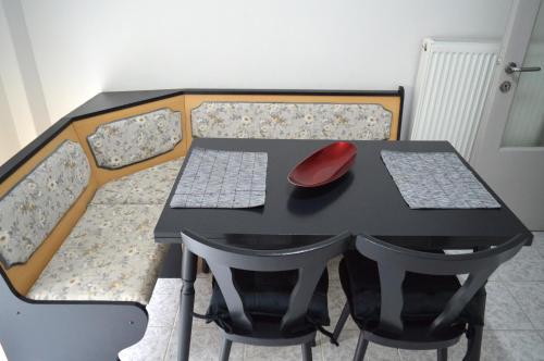 a black table with chairs and a red mouse on it at Ευρύχωρο διαμέρισμα στο κέντρο της πόλης in Kastoria
