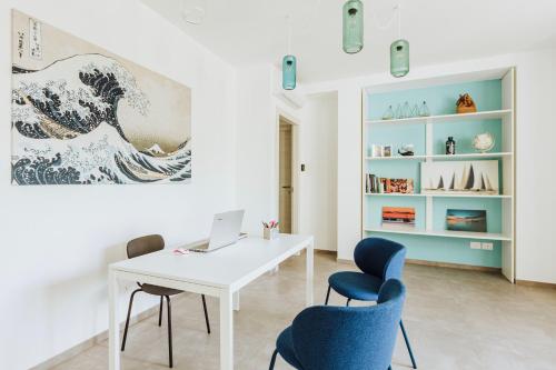 a white desk with two chairs and a laptop in a room at Marechiaro Room in Vasto