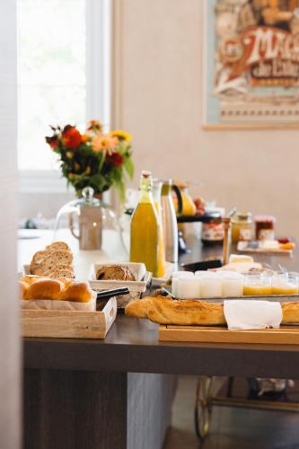 a table with bread and other foods on it at La Maison D'Olivier in Mesnard-la-Barotière