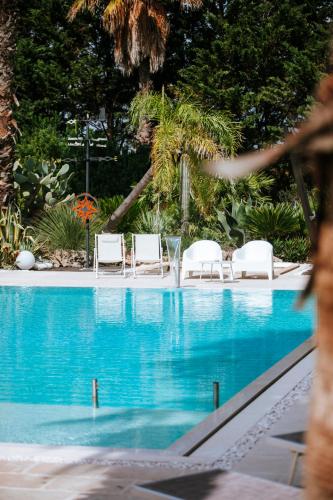 a swimming pool with lounge chairs and a swimming pool at Masseria La Tofala benessere & SPA in Copertino
