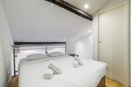 une chambre avec un lit blanc avec des serviettes dessus dans l'établissement 3 CLEMENCEAU - Duplex - dernier étage - balcon - Hyper centre, à Nice