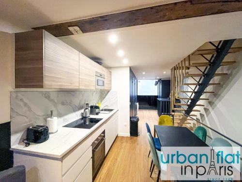 une cuisine avec un évier et une table avec des chaises dans l'établissement Urban Flat 31 - Charming Triplex in Paris, à Paris