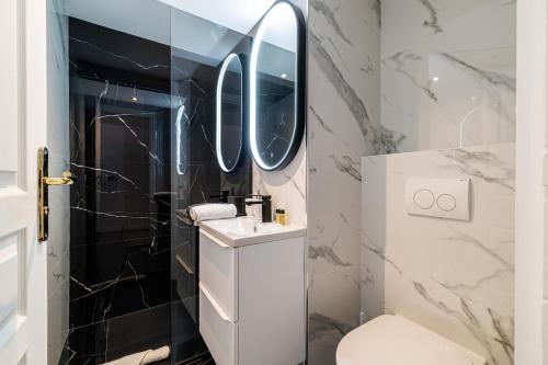 une salle de bain avec des toilettes blanches et un miroir dans l'établissement 3 CLEMENCEAU - Duplex - dernier étage - balcon - Hyper centre, à Nice