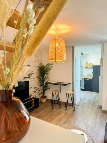 - un salon avec une table et un vase fleuri dans l'établissement Charmant Duplex Lumineux, à Angers