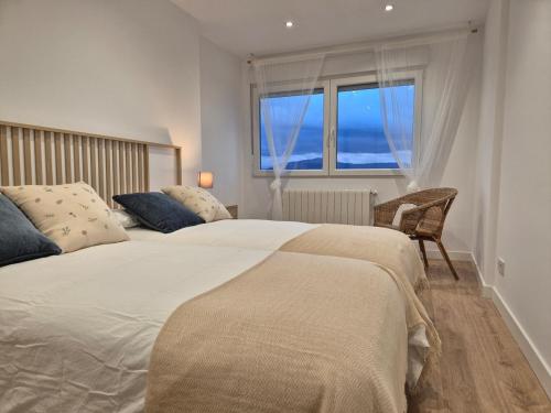 a bedroom with a large bed and a window at C01A07 Moderno apartamento con vistas in Santander