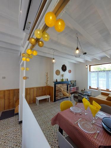 un salon avec une table et des chaises jaunes dans l'établissement Maison de campagne 6 personnes Aux volets verts, à Cappellebrouck