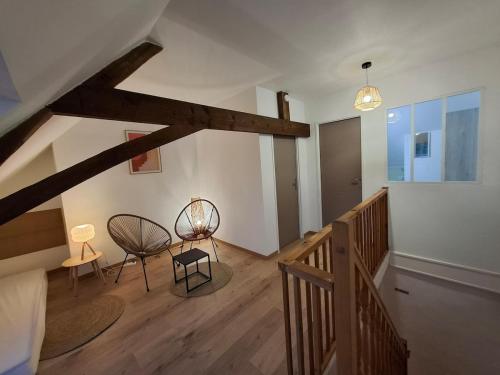 un couloir avec deux chaises et une table dans un bâtiment dans l'établissement Maison de campagne 6 personnes Aux volets verts, à Cappellebrouck