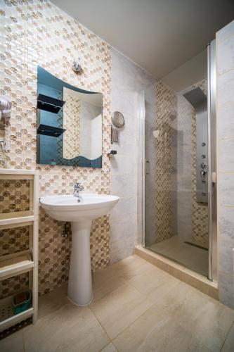 a bathroom with a sink and a shower at Hotel Zenubia in Hajdúszoboszló