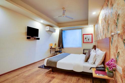 a hotel room with a bed and a television at Hotel Aerostar Grand at Yashobhoomi Convention Center in New Delhi