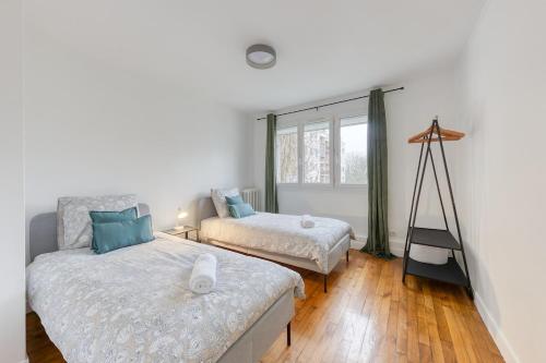 une chambre avec deux lits et une fenêtre dans l'établissement Bel appartement pour 8 personnes à 15 minutes CDG, à Saint-Denis