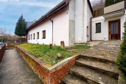 a house with a brick wall and stairs in front of it at Devils Peak Prague in Prague