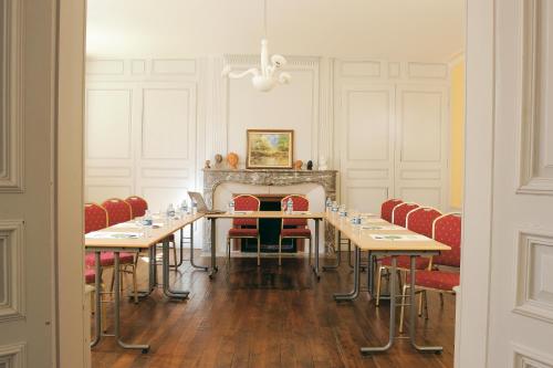 a conference room with tables and chairs and a fireplace at Logis Hôtel - Restaurant Le Tulipier in Vienne-le-Château
