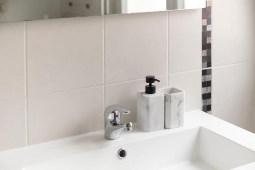 un lavabo de salle de bain avec un robinet et un miroir dans l'établissement Bel appartement pour 8 personnes à 15 minutes CDG, à Saint-Denis