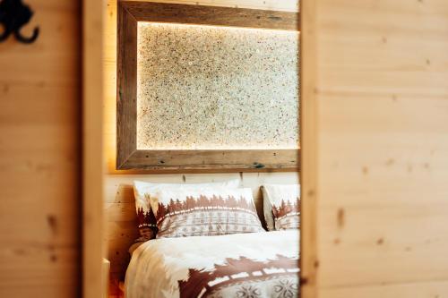 a mirror reflection of a bed in a room at le Gemme - Dolomites escape in Dosoledo