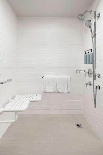 a white bathroom with a sink and a shower at Residence Inn by Marriott Montreal Airport in Dorval