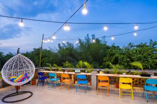 a patio with a table and chairs and lights at goSTOPS Pondicherry Near Auroville in Auroville
