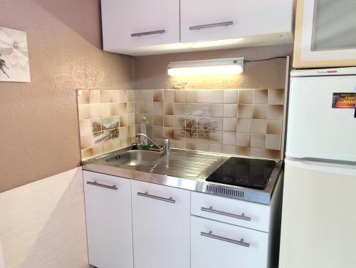 une petite cuisine avec un évier et un réfrigérateur dans l'établissement Studio le romantique à 20 kms de Nice, à Bendéjun