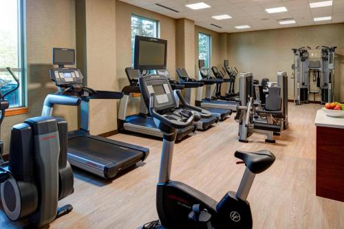 a gym with a row of treadms and cardio machines at Marriott Indianapolis North in Indianapolis