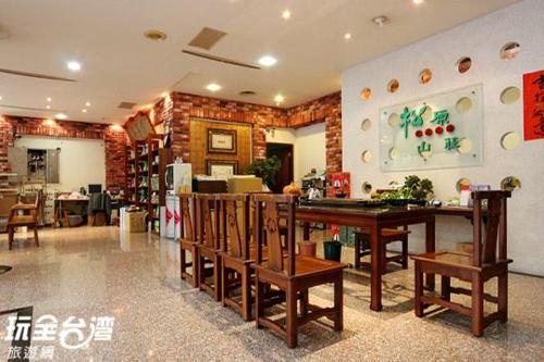 Habitación con mesa y sillas en un edificio en Songyuan B&B, en Lugu