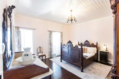 a bedroom with a bed and a chandelier at House of Lords in São João da Pesqueira
