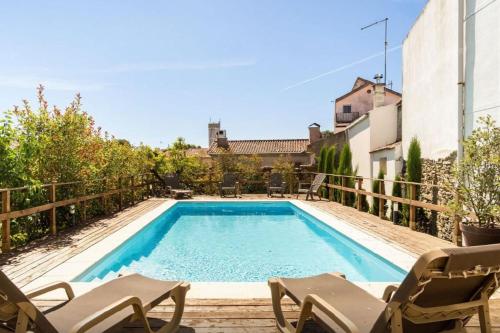 a swimming pool with chairs next to a building at House of Lords in São João da Pesqueira