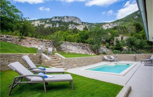 a backyard with a pool and chairs and a rock wall at Villa Orljak in Buzet