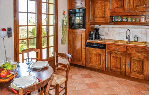a kitchen with wooden cabinets and a table and chairs at Amazing Home In Bassillac-Et-Auberoche in Le Change