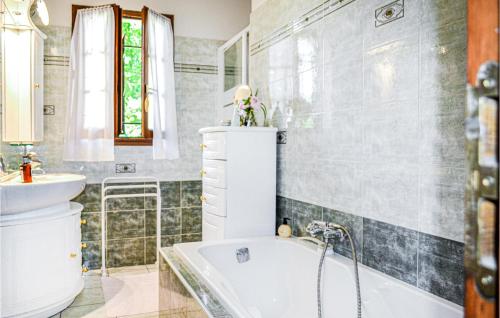 a bathroom with a tub and a sink at Amazing Home In Bassillac-Et-Auberoche in Le Change