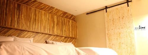 a bedroom with a bed and a wooden headboard at Jeonju Lime Hotel in Jeonju