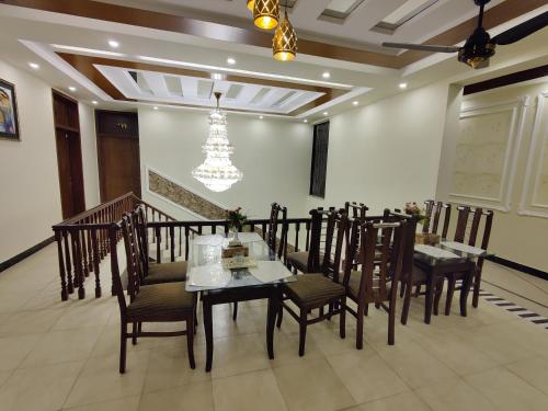a dining room with a table and chairs and a chandelier at AL Fateh Hotel in Lahore