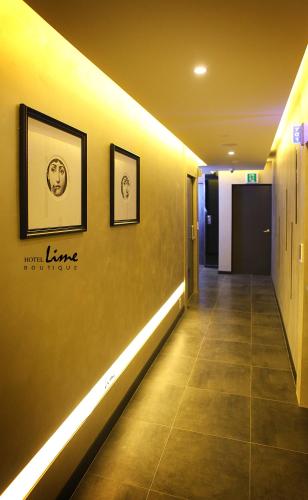 a hallway with two framed pictures on a wall at Jeonju Lime Hotel in Jeonju