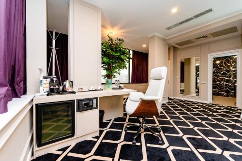 a kitchen with a counter and two chairs in a room at Business Hotel Conference Center & Spa in Târgu-Mureş