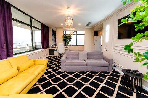 a living room with a couch and a chair at Business Hotel Conference Center & Spa in Târgu-Mureş