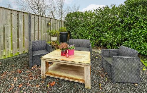 a patio with two chairs and a table with plants at Oud Kempen Bungalow 181 in Stavenisse